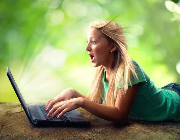 Förvånad tonårsflicka med laptop — Stockfoto