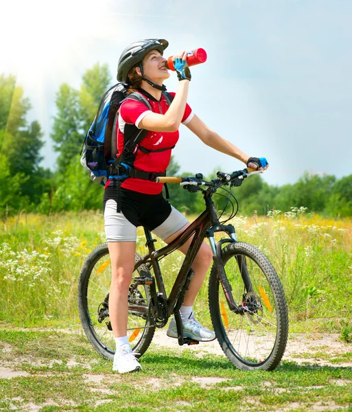 Mujer joven montando bicicleta — Foto de Stock