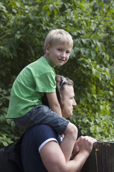 Pojke sitter vid fadern på axlar — Stockfoto