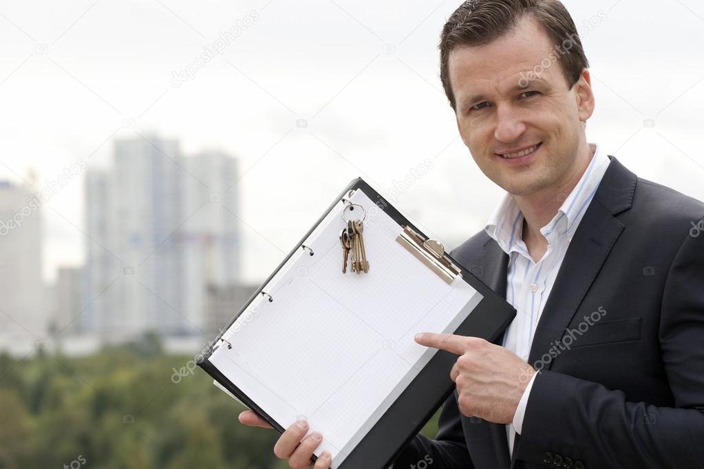 Businessman holding the Pure White Sign with keys from the new h