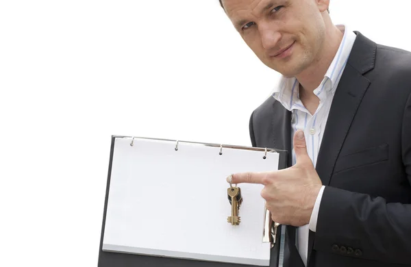 Real estate agent holds out the front door key — Stock Photo, Image