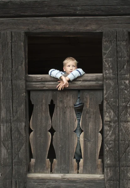 Menino na velha casa de madeira — Fotografia de Stock