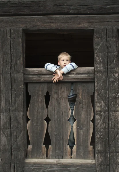 Boy in the old wooden house Royalty Free Stock Images