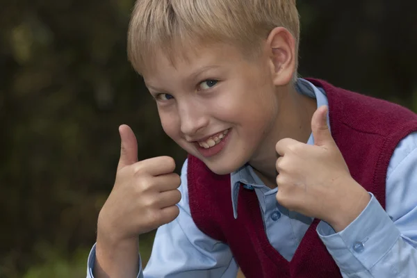 Uśmiechnięty chłopiec dając kciuki — Zdjęcie stockowe