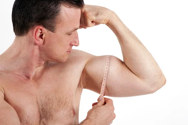 Strong man measuring his bicep muscle. Isolated on white backgro — Stock Photo, Image