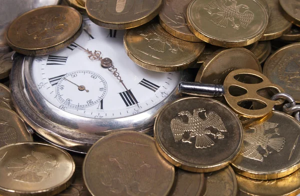 Čas je pojem peníze. mince a staré kapesní hodinky. — Stock fotografie