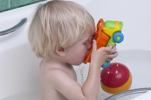 Niedlicher kleiner Junge beim Baden mit Spielzeug — Stockfoto