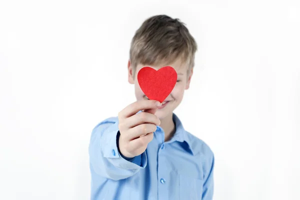 男孩把自己藏起来背后一颗红色的心. — 图库照片