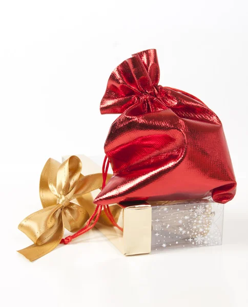 Красная сумка с подарками и золотой лук — стоковое фото