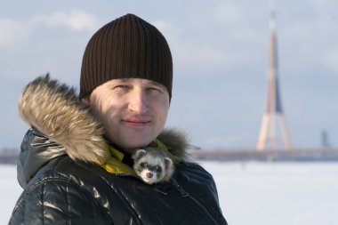 Man with ferret  in winter outdoor clipart