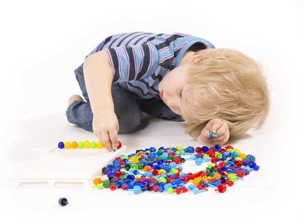 Child plays with a mosaic — Stock Photo, Image