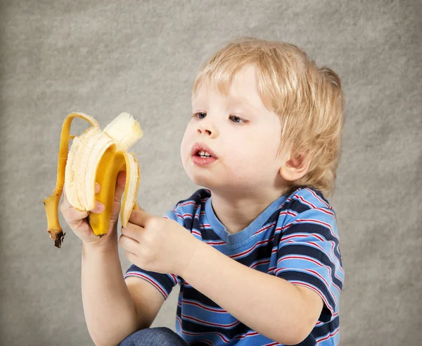 Сhild eats banana — Stock Photo, Image