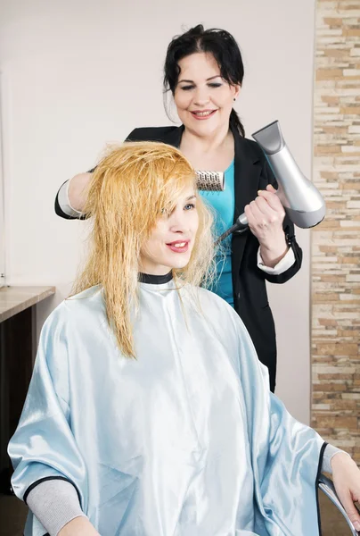 Friseur trocknet Haare — Stockfoto