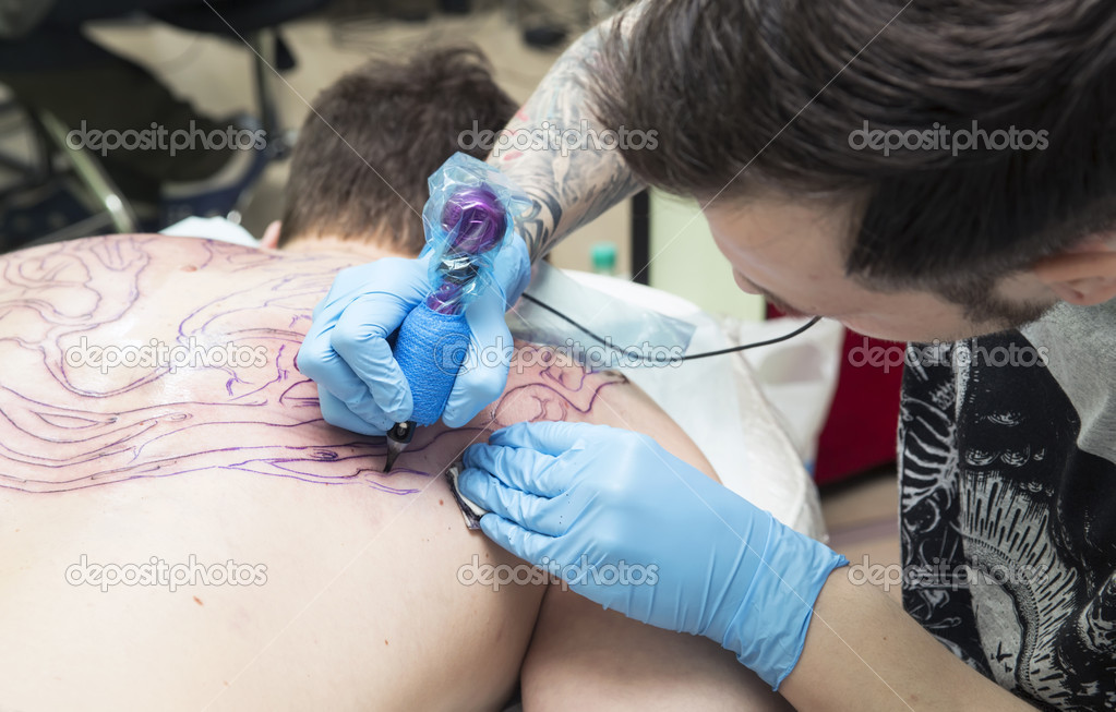 Tattooer does a tattoo