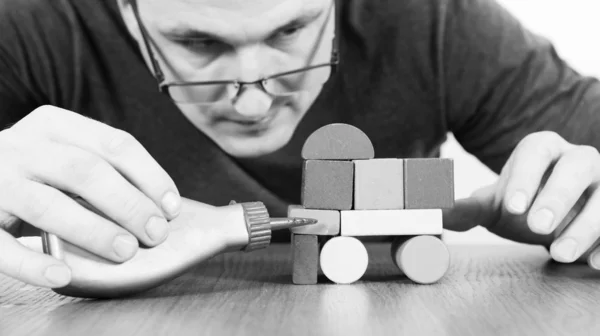 Man glues the car of toy blocks — Stock Photo, Image