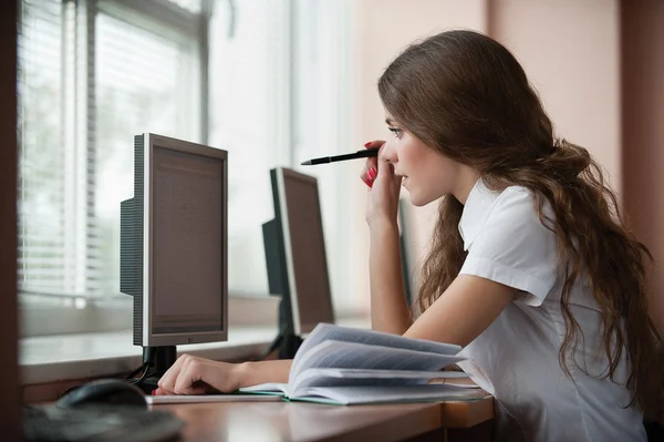 Een jonge vrouw die werkt op een computer — Stockfoto