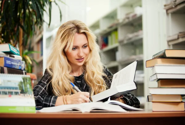 Young beautiful blonde girl in a library — Stock Photo, Image