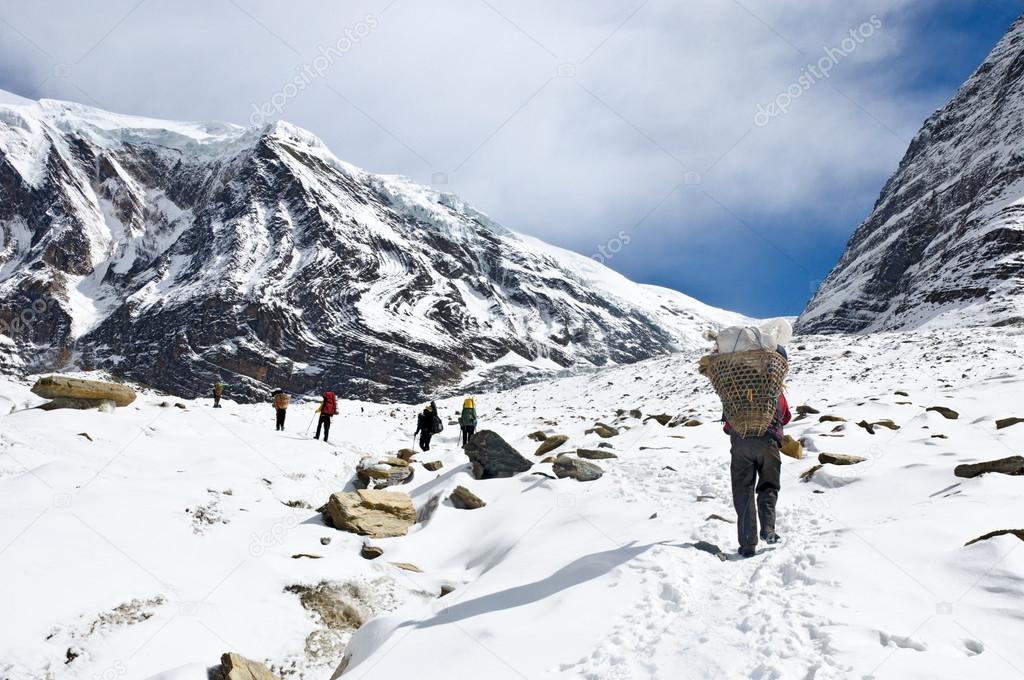 Team of trekkers and porters in Himalaya mountains