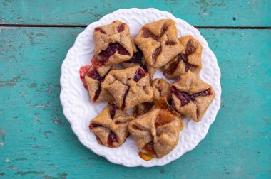 Çek cheesecake pastası katlanmış küp bisküviler kırmızı reçelle sarılmış yeşil mavi kırsal çizilmiş vintage arka plan