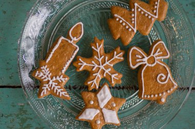 Geleneksel Noel zencefilli çörekleri eski, yeşil ve mavi renkli masalara dizilmiş, güpegündüz boyanmış, sıradan, tatlandırıcı tatlılar