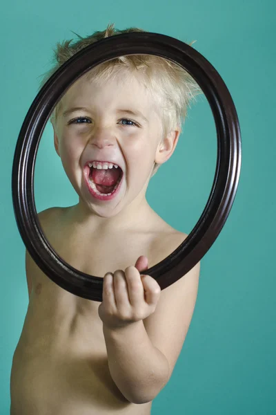 Boy screaming behind picture frame — Stock Photo, Image