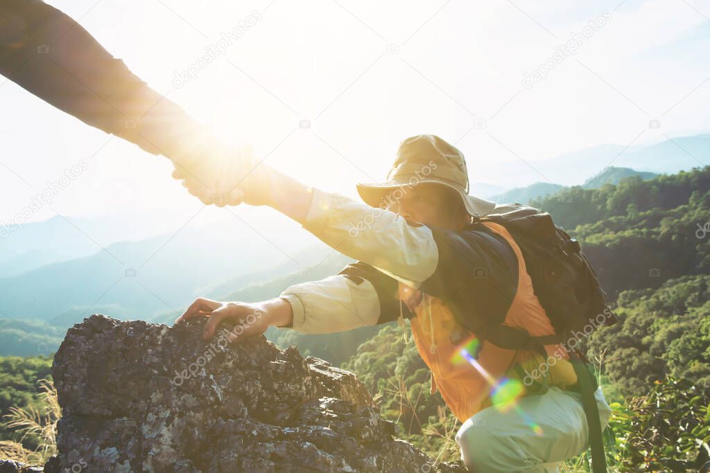 Close-up of helping hand, hiking help each other. Focus on hands. People teamwork climbing or hiking with motivation and inspiration.