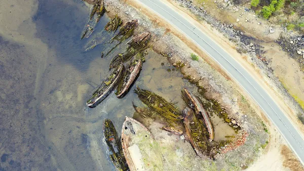 Rusya 'nın Teriberka Kola Yarımadası yakınlarındaki yol kenarındaki eski ahşap gemi mezarlığı. Hava aracı fotoğrafı. Üst alt görünüm