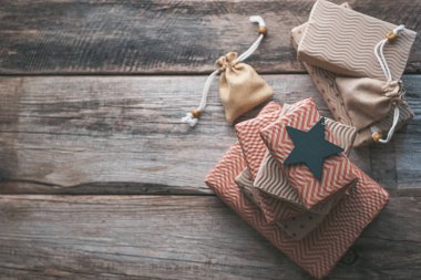 Tahta bir arka planda el işi kağıdında hediye kutularındaki Noel yıldızı. Sıfır atık, plastik yok. Metin için boşluk. Yüksek kalite fotoğraf