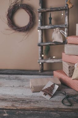 Arka plandaki hediye kutularındaki ahşap dallardan yapılmış yaratıcı sürdürülebilir eko Noel etiketi. Sıfır israf Noel konsepti, eko dekor. Yüksek kalite fotoğraf