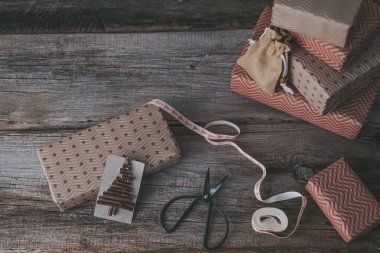 Arka plandaki hediye kutularındaki ahşap dallardan yapılmış yaratıcı sürdürülebilir eko Noel etiketi. Sıfır israf Noel konsepti, eko dekor. Yüksek kalite fotoğraf. Yüksek kalite fotoğraf