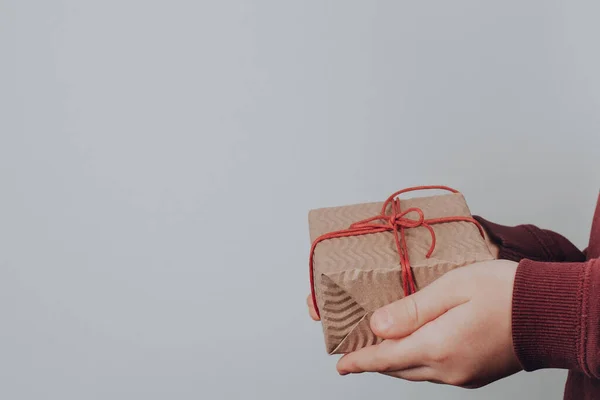 Kinderhände Mit Weihnachtsgeschenken Eingewickelt Kraftpapier Auf Grauem Hintergrund Weihnachten Und — Stockfoto