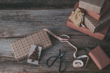 Arka plandaki hediye kutularındaki ahşap dallardan yapılmış yaratıcı sürdürülebilir eko Noel etiketi. Sıfır israf Noel konsepti, eko dekor. Yüksek kalite fotoğraf. Yüksek kalite fotoğraf