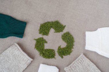 Kıyafet geri dönüşümü. Ekolojik ve sürdürülebilir moda. Kışın örülmüş kazaklı kollar. Noel ağacı iğneleriyle geri dönüşüm tabelası. Yüksek kalite fotoğraf. Yüksek kalite fotoğraf