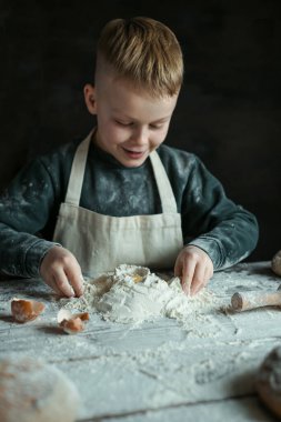 Child playing with flour in the kitchen. High quality photo