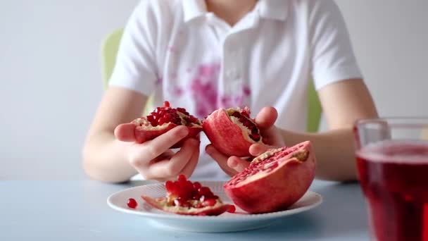 Kinderhände öffnen einen frischen Granatapfel. Drecksfleck im Alltag — Stockvideo