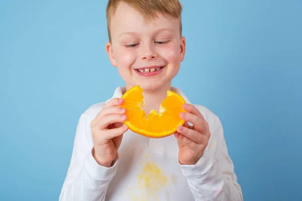 Chlapec Drží Půlku Pomeranče Špinavé Skvrny Pomerančového Džusu Oblečení Koncept — Stock fotografie