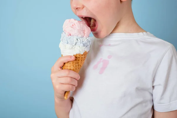 Niño irreconocible comiendo helado. mancha sucia de helado de fresa en la ropa blanca. vida cotidiana mancha y concepto de limpieza — Foto de Stock