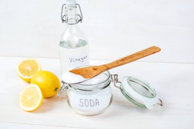 Kavanozda kabartma tozu, üstünde tahta kaşık, sirke, beyaz arka planda limon. Kıyafetlerdeki lekeleri çıkarma fikri. Yüksek kalite fotoğraf