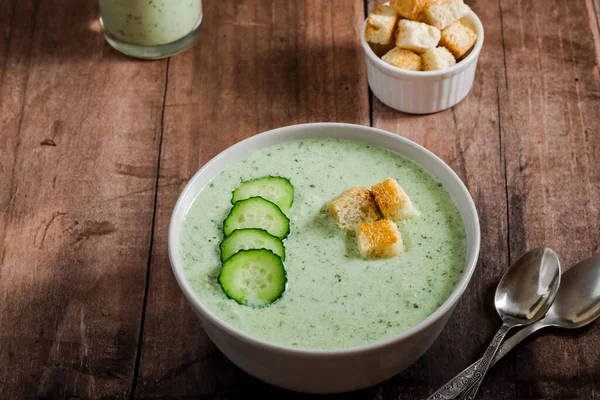 Salatalık Gazpacho. Salatalık dilimli yeşil soğuk çorba ve ahşap zemin üzerinde kızarmış ekmek. sağlıklı vejetaryen yemeği. Yüksek kalite fotoğraf