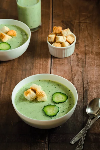 Salatalık Gazpacho. Yeşil taze soğuk çorba, salatalık dilimi ve ahşap bir masada kızarmış ekmek. sağlıklı vejetaryen yemeği. Yüksek kalite fotoğraf