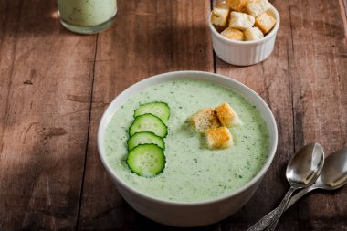 Salatalık Gazpacho. Salatalık dilimli yeşil soğuk çorba ve ahşap zemin üzerinde kızarmış ekmek. sağlıklı vejetaryen yemeği. Yüksek kalite fotoğraf