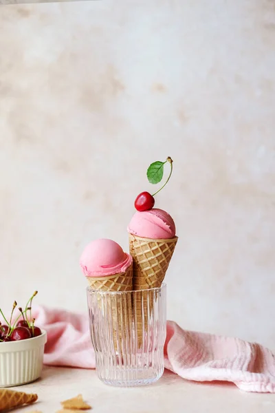 Creamy vegan cherries ice cream in the horn in a glass, styling cherry on top. Summer seasonal cold sweet healthy vegan dessert. High quality photo