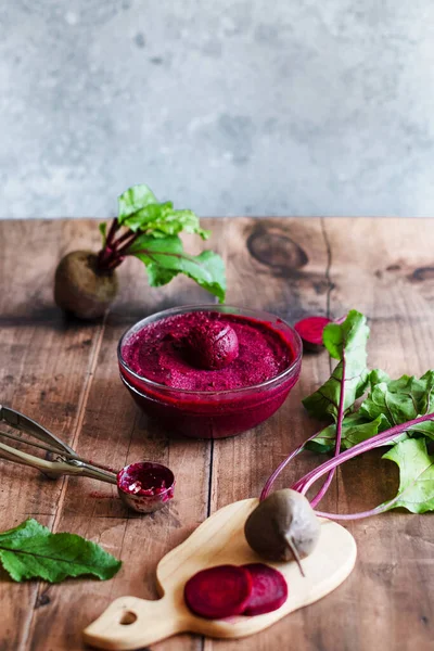 Ahşap bir masada ev yapımı vejetaryen pancar dondurması. Pancar kökü dondurmalı cam tabak. Sağlıklı dondurulmuş vejetaryen soğuk tatlı. Yüksek kalite fotoğraf