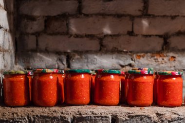 Canned food on a brick shelf in a bomb shelter. food supplies in glass jars. High quality 4k footage
