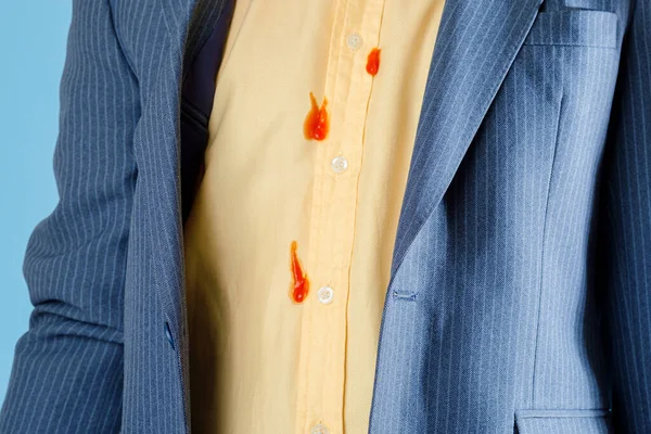 Beklenmedik bir kazadan kalma sarı bir gömlekteki kirli kırmızı yemek lekeleri. Günlük yaşam lekesi konsepti. Yüksek kalite fotoğraf