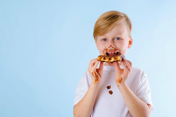 Dítě Belgické Vafle Čokoládovou Omáčkou Modrém Pozadí Špinavé Čokoládové Skvrny — Stock fotografie