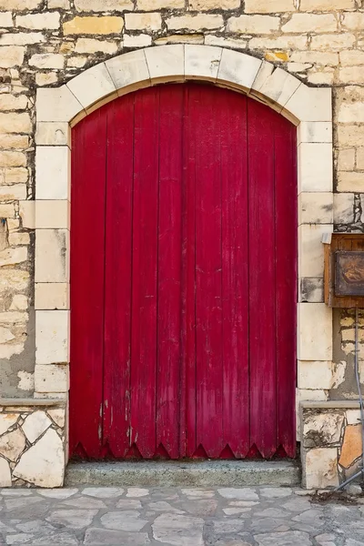 Old red door against stone wall
