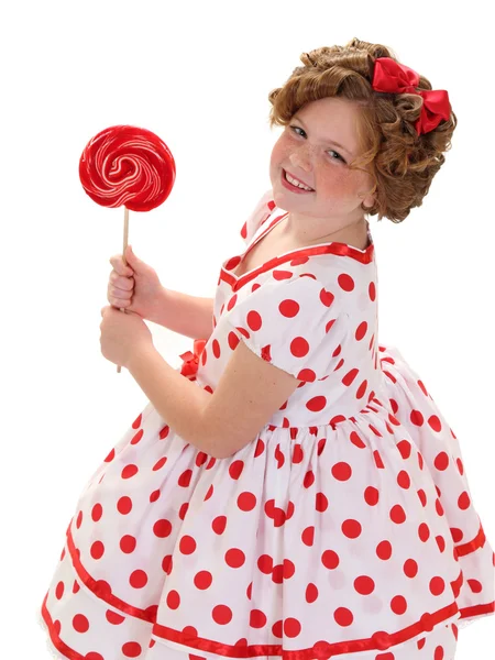 Een meisje heeft een rode lolly — Stockfoto