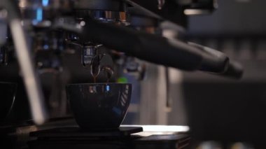 Unrecognizable barista preparing cup of coffee in coffee machine, close up. Process of making hot coffee in coffee shop