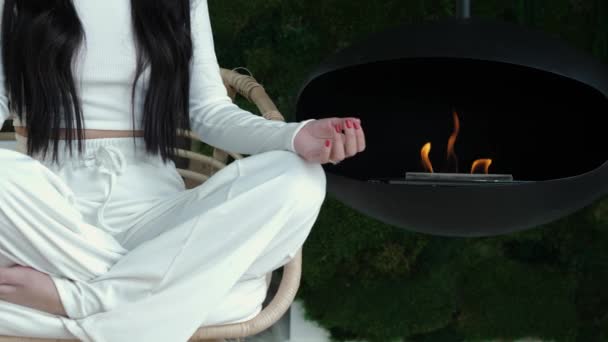 Unrecognizable Woman Sits Cross Legged Chair Room Greenery Fireplace Practices — Vídeo de Stock